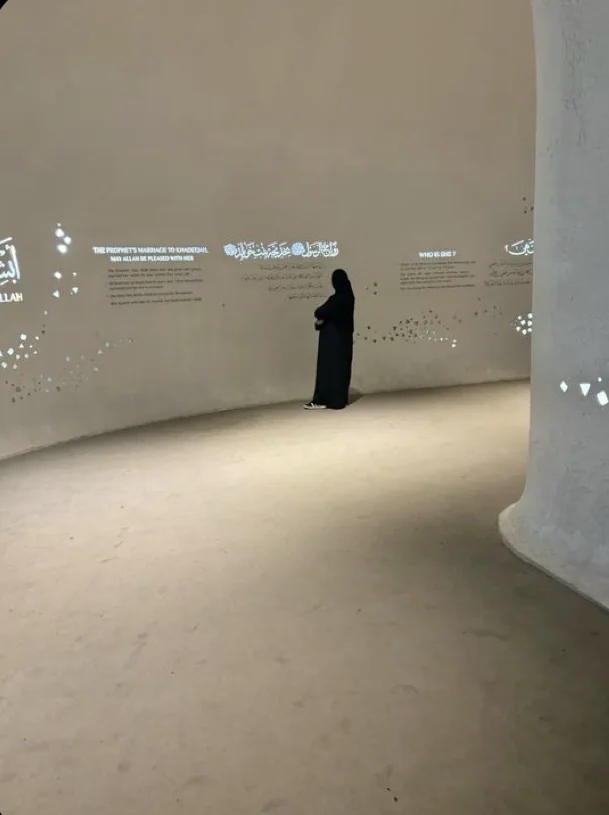 Visite d’une salle de musée avec des textes projetés au mur