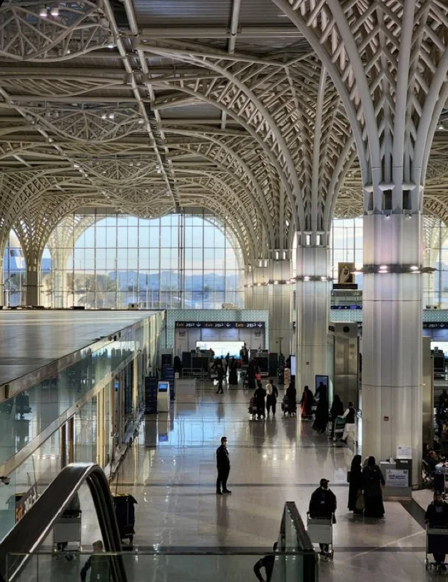 Grand hall de terminal avec une verrière et des voyageurs